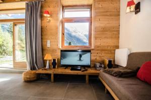 夏慕尼白朗峰的住宿－Résidence Panorama - Chalets pour 6 Personnes 024，客厅设有木墙,配有电视