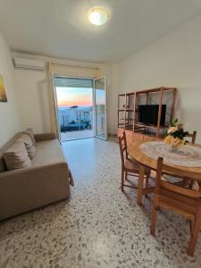 een woonkamer met een tafel en een bank bij TamarHouse Sperlonga Casa Naila in Sperlonga