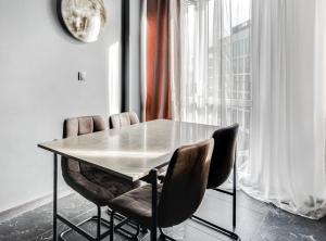 a table and chairs in a room with a window at BLACKNIGHT Apartment - Self Check-In 24h in Wrocław