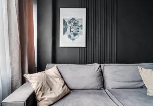 um sofá numa sala de estar com uma fotografia na parede em BLACKNIGHT Apartment - Self Check-In 24h em Breslávia