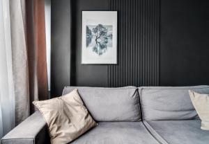 a couch in a living room with a picture on the wall at BLACKNIGHT Apartment - Self Check-In 24h in Wrocław