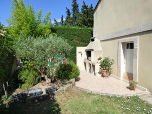 un edificio con una pasarela junto a un jardín en Chambre d'Hôtes entre Provence et Camargue en Beaucaire