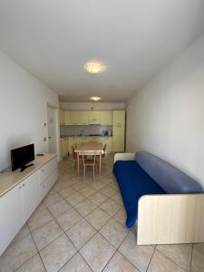 a bedroom with a bed and a table and a kitchen at RESIDENCE STEFANIA Appartamenti piano terra - AGENZIA COCAL in Caorle