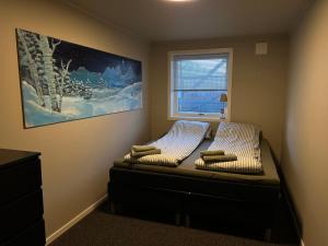 a bed in a room with a picture on the wall at Your home away from home, apartment 1 in Tromsø