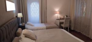 Buguggiateにある"La Selvetta" bed and breakfastのベッド2台とデスクが備わるホテルルームです。