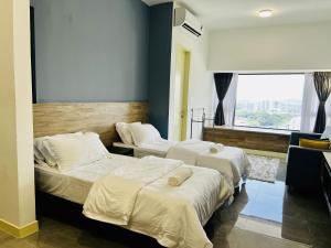 Cette chambre comprend 2 lits et une fenêtre. dans l'établissement Imperio Residence Melaka by Dream View, à Malacca