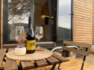 stół z 2 butelkami wina i 2 kieliszkami w obiekcie Caseta Wald w mieście Las Serras