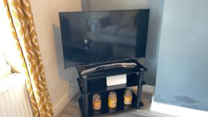 een televisie op een stand met flessen bier bij Herbert - Duplex Relocations in Mexborough