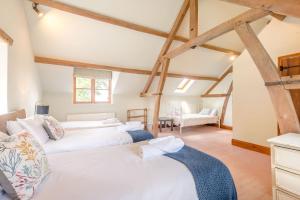 two beds in a room with wooden beams at The Chestnuts in Tenbury
