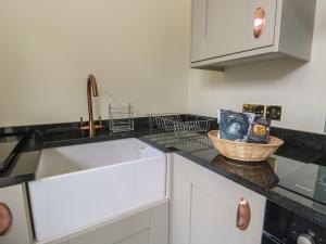 a kitchen with a sink and a basket on the counter at The Stables in Denbigh