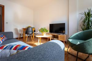a living room with a couch and a tv at Apartamento Balcón de Liérganes in Liérganes