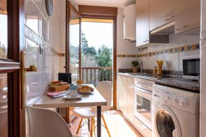 a kitchen with a washer and dryer and a table at Apartamento Balcón de Liérganes in Liérganes