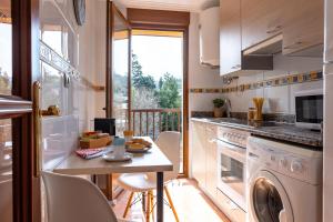 cocina con lavadora, secadora y mesa en Apartamento Balcón de Liérganes, en Liérganes