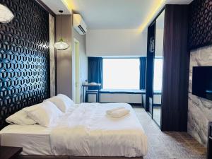 - une chambre avec un grand lit et une grande fenêtre dans l'établissement Imperio Residence Melaka by Dream View, à Malacca