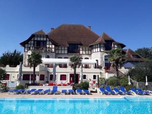 a large building with chairs and a swimming pool at Villa Campagne 138 in Daumazan-sur-Arize