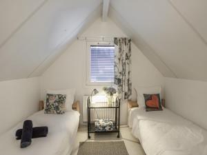 a attic room with two beds and a window at Villa Campagne 138 in Daumazan-sur-Arize