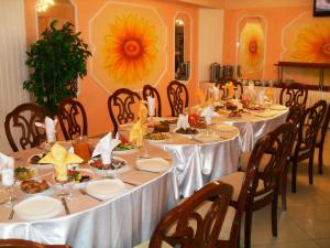 a dining room with tables and chairs with food on them at Ust-Kamenogorsk Hotel in Ustʼ-Kamenogorsk