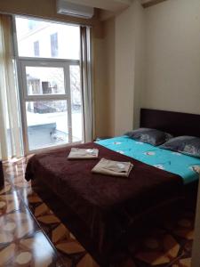 a bedroom with a large bed with two towels on it at New Saburtalo Star in Tbilisi City