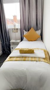 een slaapkamer met een groot wit bed met gele kussens bij Herbert - Duplex Relocations in Mexborough