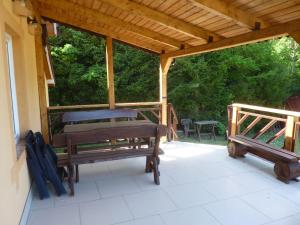 - un pavillon avec 2 bancs sur une terrasse dans l'établissement Dom nad stawem, à Żywki