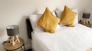 um quarto com uma cama com almofadas amarelas e 2 candeeiros em Herbert - Duplex Relocations em Mexborough