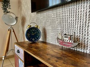 a clock sitting on top of a wooden table at Apartament Klifowy Raj SPA & Restaurant by Stayly in Niechorze