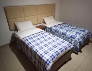 dos camas sentadas una al lado de la otra en una habitación en SKYLIGHT MOTEL Airport Road, en Kigali