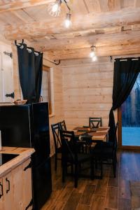 comedor con mesa y sillas en una cabaña en Domek pod lasem-Orawskie Ranczo, en Harkabuz