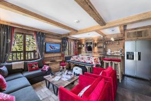 a living room with red furniture and a kitchen at Résidence Ajacour - Chalets pour 8 Personnes 034 in Courchevel