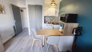 una pequeña cocina con mesa de madera y sillas en Arc en ciel, en Saint-Jean-de-Monts