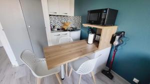 cocina pequeña con escritorio con sillas y microondas en Arc en ciel, en Saint-Jean-de-Monts