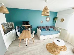 una sala de estar con un sofá y una mesa en Arc en ciel, en Saint-Jean-de-Monts