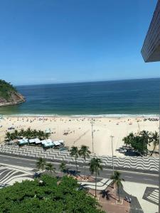 una spiaggia con molta gente e l'oceano di suite deluxe vista mar Copacabana - entrada independente a Rio de Janeiro