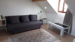 uma sala de estar com um sofá e uma mesa em Jeux Olympiques 2024, Stade de France em Saint-Denis