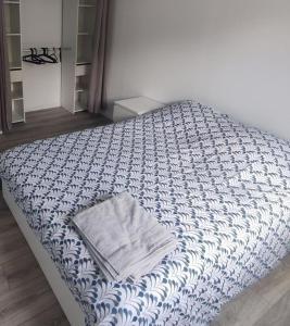 uma cama com um cobertor azul e branco em Jeux Olympiques 2024, Stade de France em Saint-Denis