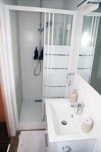 ein Badezimmer mit einem weißen Waschbecken und einer Dusche in der Unterkunft Eiffel Tour Cosy chesterfield in Paris
