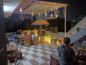 a group of people sitting under an umbrella on a roof at Taj Street Hostel in Agra