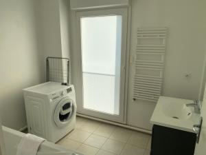 uma casa de banho com uma máquina de lavar roupa e um lavatório em Le 147 Parc Entre Paris et Disney em Champigny-sur-Marne