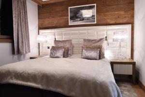 a bedroom with a large white bed with two lamps at Résidence Carre Blanc - 2 Pièces pour 2 Personnes 084 in Courchevel