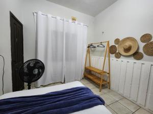 a bedroom with a bed and a white shower curtain at Mini Hostel in Tutóia
