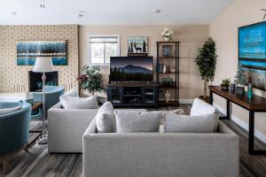 a living room with two couches and a tv at Gallatin Gateway Getaway in Bozeman