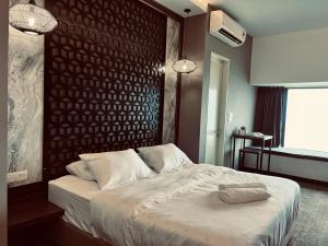 - une chambre avec un lit blanc et un mur en bois dans l'établissement Imperio Residence Melaka by Dream View, à Malacca