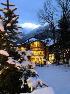 a snow covered christmas tree in front of a house at Résidence Prosper - Chalets pour 12 Personnes 154 in Courchevel