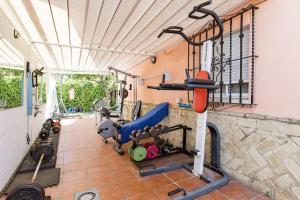 uma sala de fitness com um ginásio com pesos em Apartamento privado con piscina y jardin compartidos. em Valencina de la Concepción