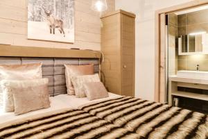 ein Schlafzimmer mit einem großen Bett und einem Waschbecken in der Unterkunft Résidence Carre Blanc - 5 Pièces pour 8 Personnes 264 in Courchevel