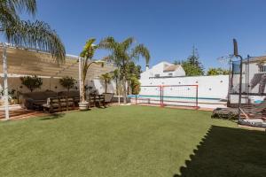 un patio trasero con pista de voleibol y piscina en Apartamento privado con piscina y jardin compartidos., en Valencina de la Concepción
