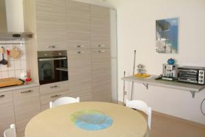 een keuken met een tafel en een tafel en stoelen bij GIAMPIERO ampio appartamento con 4 camere e 2 bagni in Sirolo