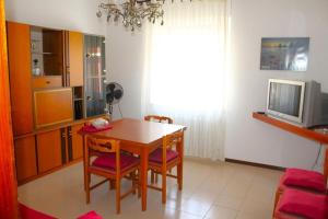 een keuken met een tafel en stoelen en een televisie bij GIAMPIERO ampio appartamento con 4 camere e 2 bagni in Sirolo