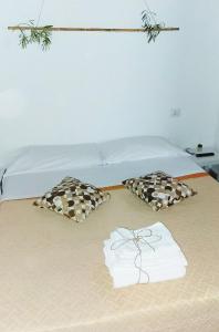 un letto con due cuscini sopra di Casa Giada sul mare a Torrenova