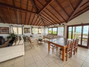 uma grande sala de estar com uma mesa e um sofá em Pousada La Belle Maison Brigitte Bardot em Búzios